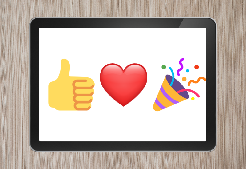 Icons on a tablet screen showing thumbs up, a heart, and a celebration popper
