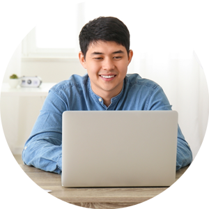 Man smiles in front of laptop