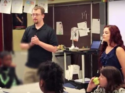 Two teachers speak to classroom
