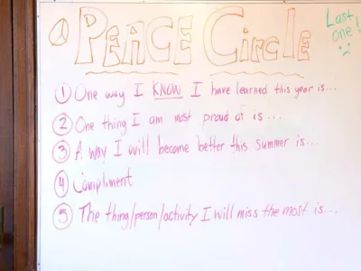 White board showing conversation prompts for students for a Peace Circle meeting
