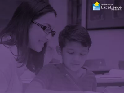 Teacher sits with student at desk, looking down at work, overlaid by purple gradient text and a logo for the Foundation for Excellence in Education
