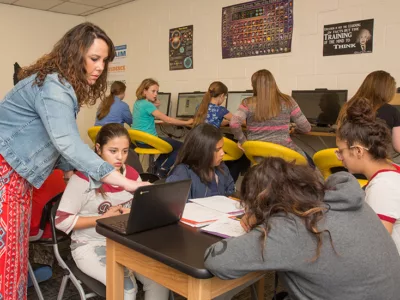 Wide view of teacher working with students in classroom

