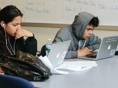 Two students working on laptops
