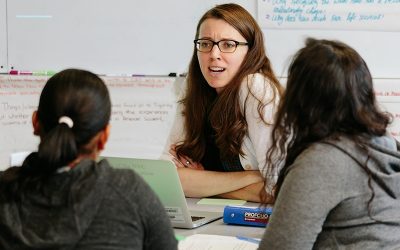 Teacher talks to two students