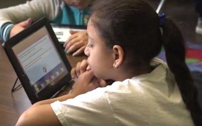 Photo closeup of student reading on her tablet device