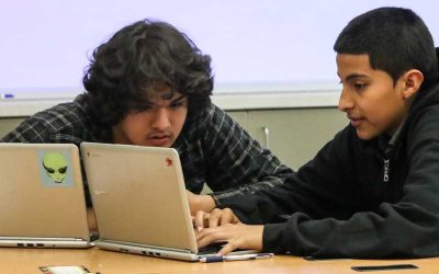 Photo of two students working together in front of laptop