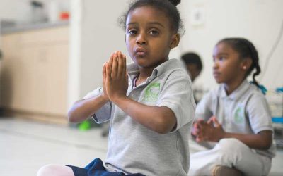 Photo closeup of student with hands together at heart center for mindfulness