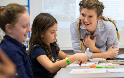 Teacher smiles as she talks with a student