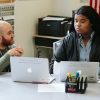 Teacher speaks to student as she looks at laptop