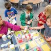 Teacher and four students look over project that shows a small 3-D model of a city