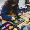 Student works on project, placing colorful blocks in a small grid