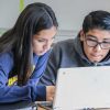 Photo of two students working together in front of laptop