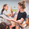 Photo of student and teacher giving each other high-five celebrating sucess